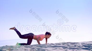 健康，年轻的美女做，做俯卧撑，在海滩上，日出时，做运动来平衡和平衡